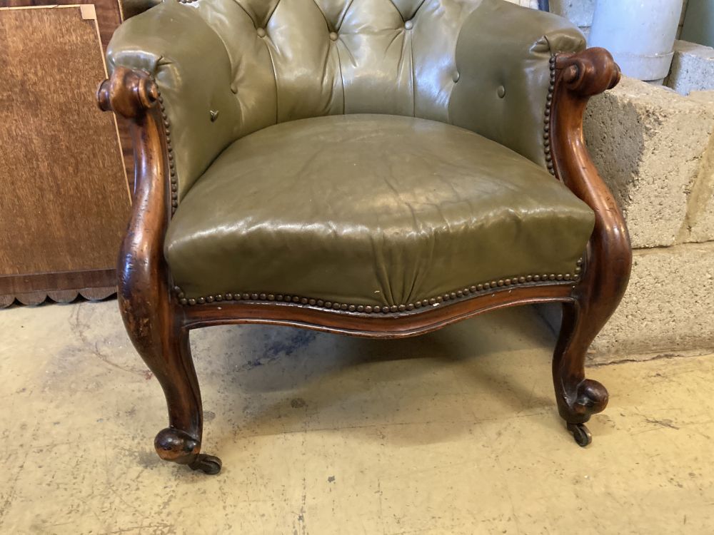 A Victorian carved and moulded showood frame spoonback armchair on scrolled legs, upholstered in buttoned green hide, width 68cm, heigh